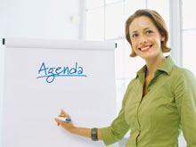 Leader pointing to agenda on flip chart