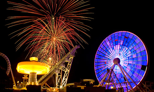 Neon ferris wheel and fireworks