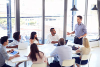 Speaker at conference table with employees