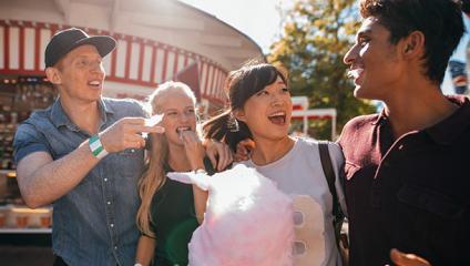 Friends on a boardwalk eating cotton candy