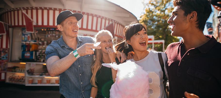 Friends on a boardwalk eating cotton candy